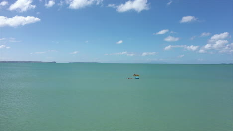 Teams-Of-Lifeguards-In-The-Bright-Blue-Sea-During-Rescue-Safety-Training-In-Summer---aerial-drone