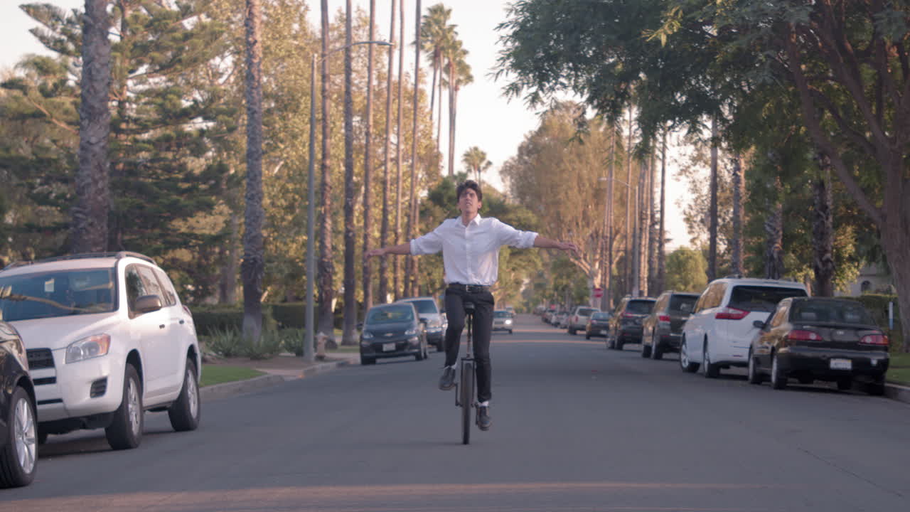 A man riding a unicycle down a street