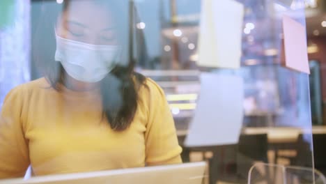 attractive asian female freelance with face mask concentrate focus on new project work startup with laptop technology device at co working space or cafe restaurant with e-commermerce online marketing