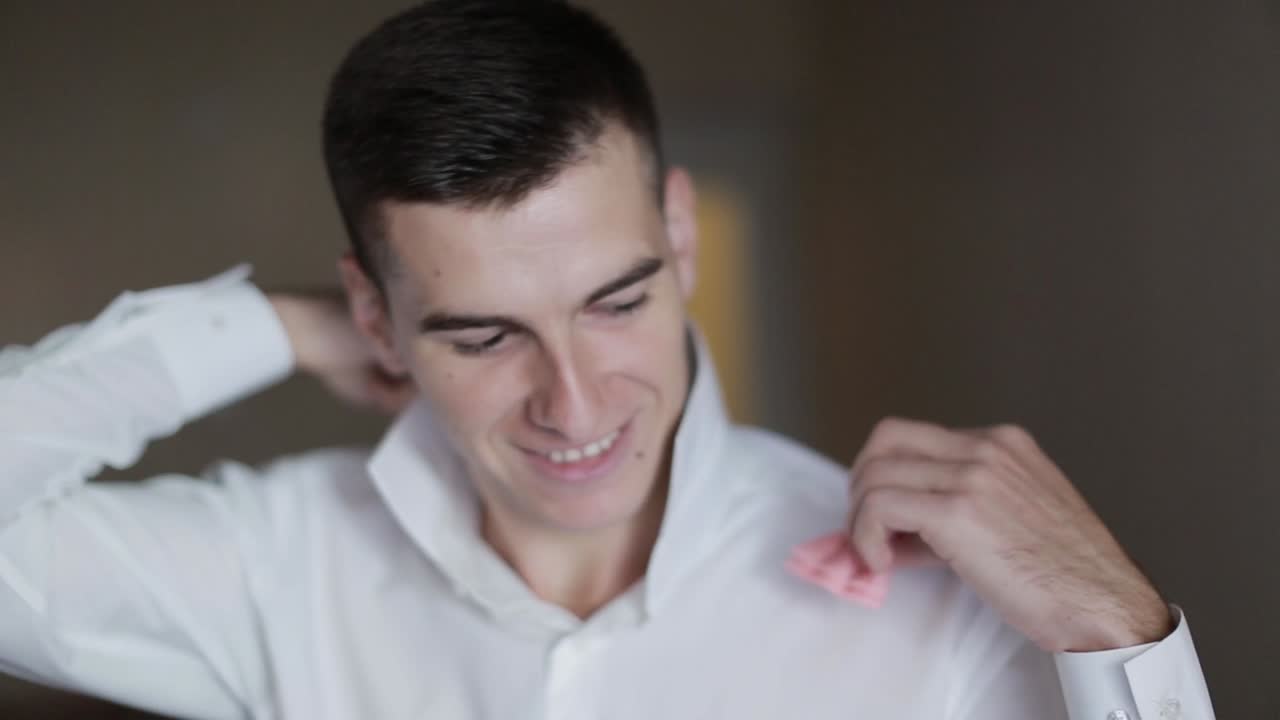 Groom Getting Ready In The Morning. Handsome groom getting dressed and preparing for the wedding