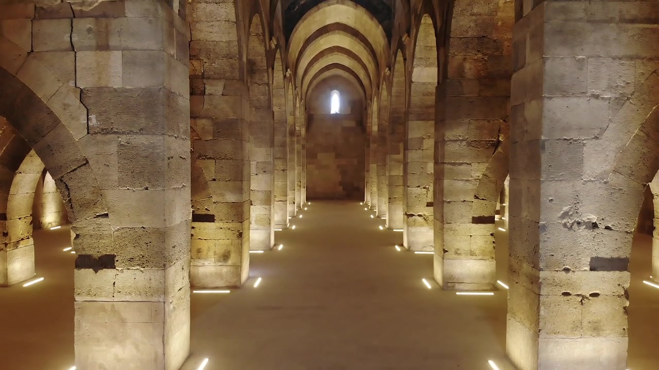 Vista Interior de um Antigo Salão Abobadado de Pedra com Iluminação Quente