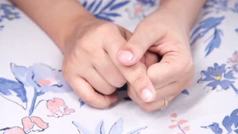 woman's hands resting on a floral table