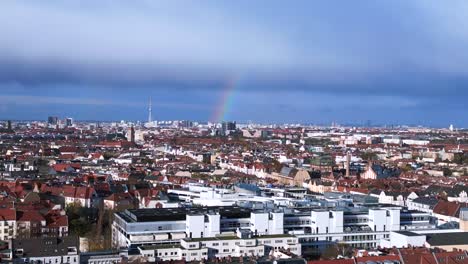 Fantástica-Vista-Aérea-Superior-Vuelo-Arco-Iris-En-Cielo-Nublado-Gris,-Ciudad-Berlín-Distrito-Mitte-Alemania