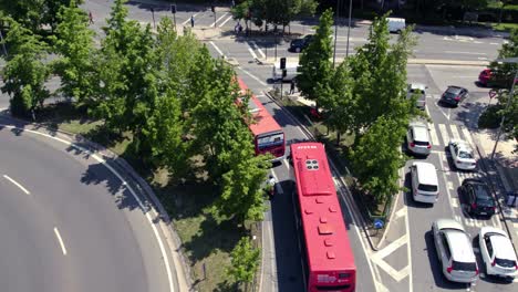 aerial drone fly above street traffic of santiago, chile in summer, cars drive along junction, red buses, public transportaton