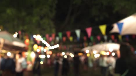 asian traditional festival in the garden people walking buying shopping and eating wiht lights and flags at night