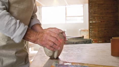 female potter molding a clay