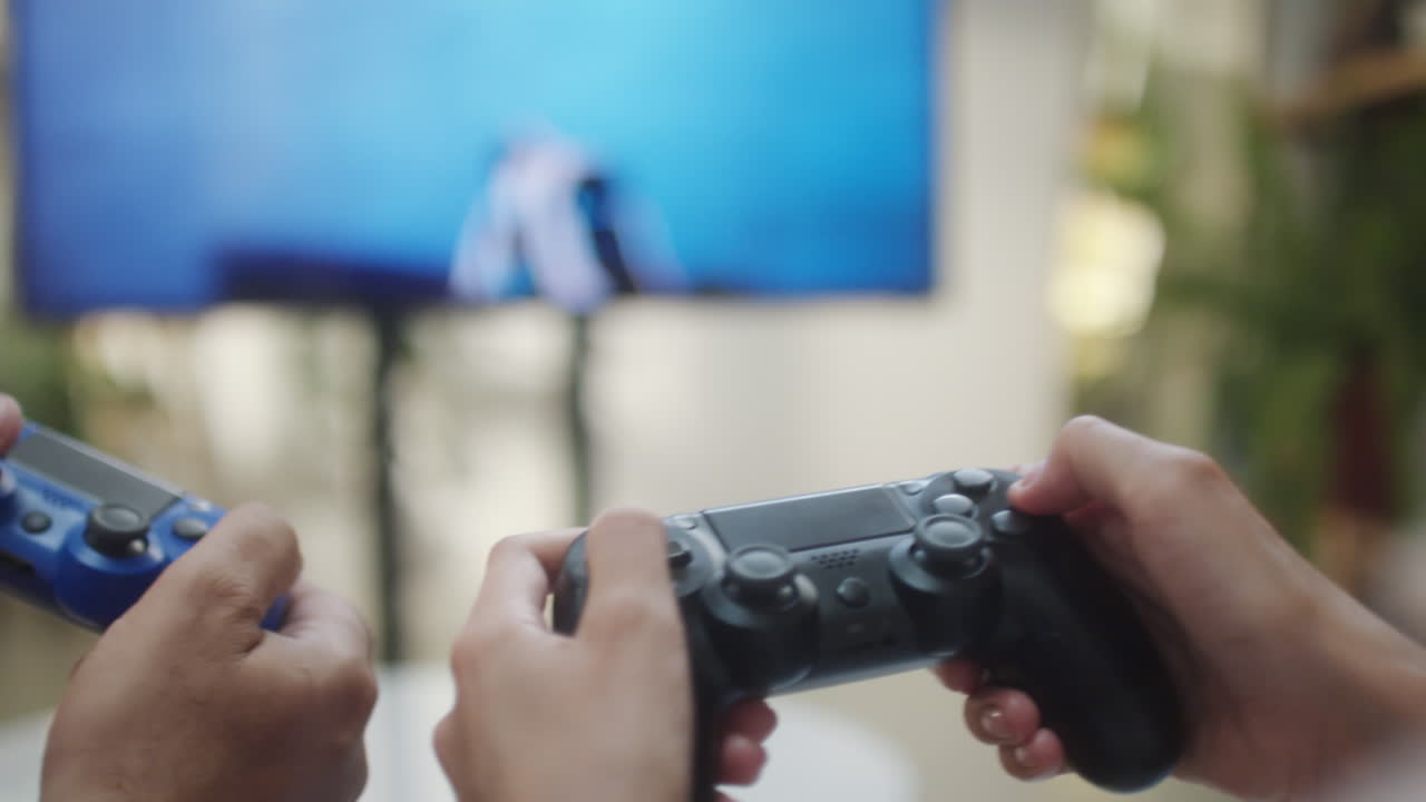 Close-up of hands playing video games with controllers