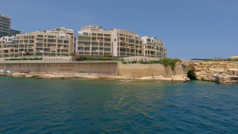 Shot-of-waterfront-city-buildings-under-construction-along-the-shore-in-Gzira,-Il-Gzira,-Malta-on-a-sunny-day