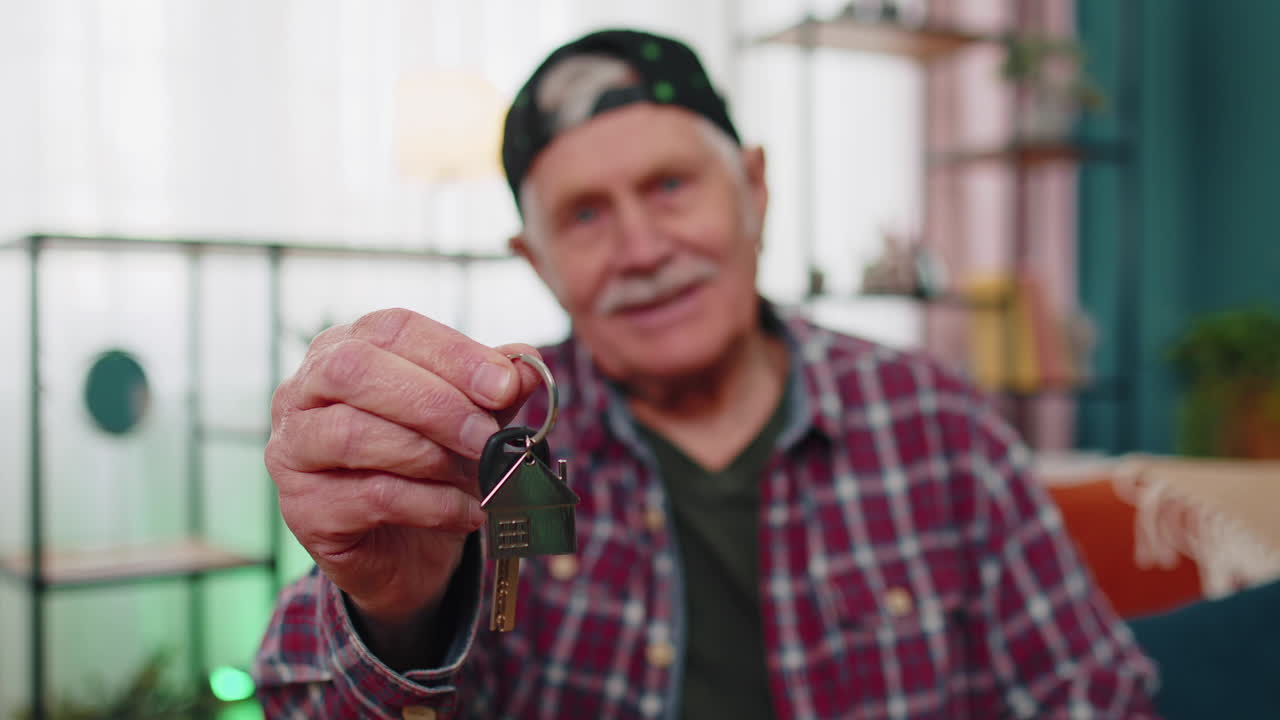 hombre de edad avanzada cliente propietario tiene la llave de la nueva casa propietario de bienes raíces hacer venta alquiler compra