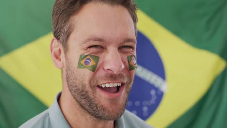 video of excited caucasian man with flag of brazil watching match in tv