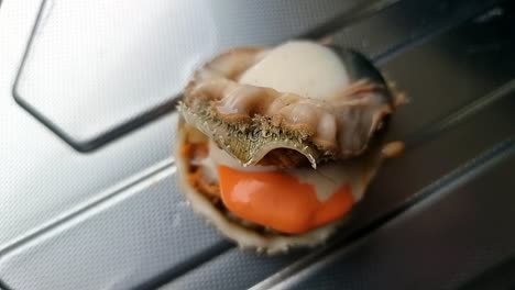 freshly baked exotic bay scallop edible saltwater clam without it's shell on aluminium kitchen surface