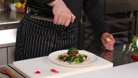 chef pouring olive oil on a delicious pasta dish