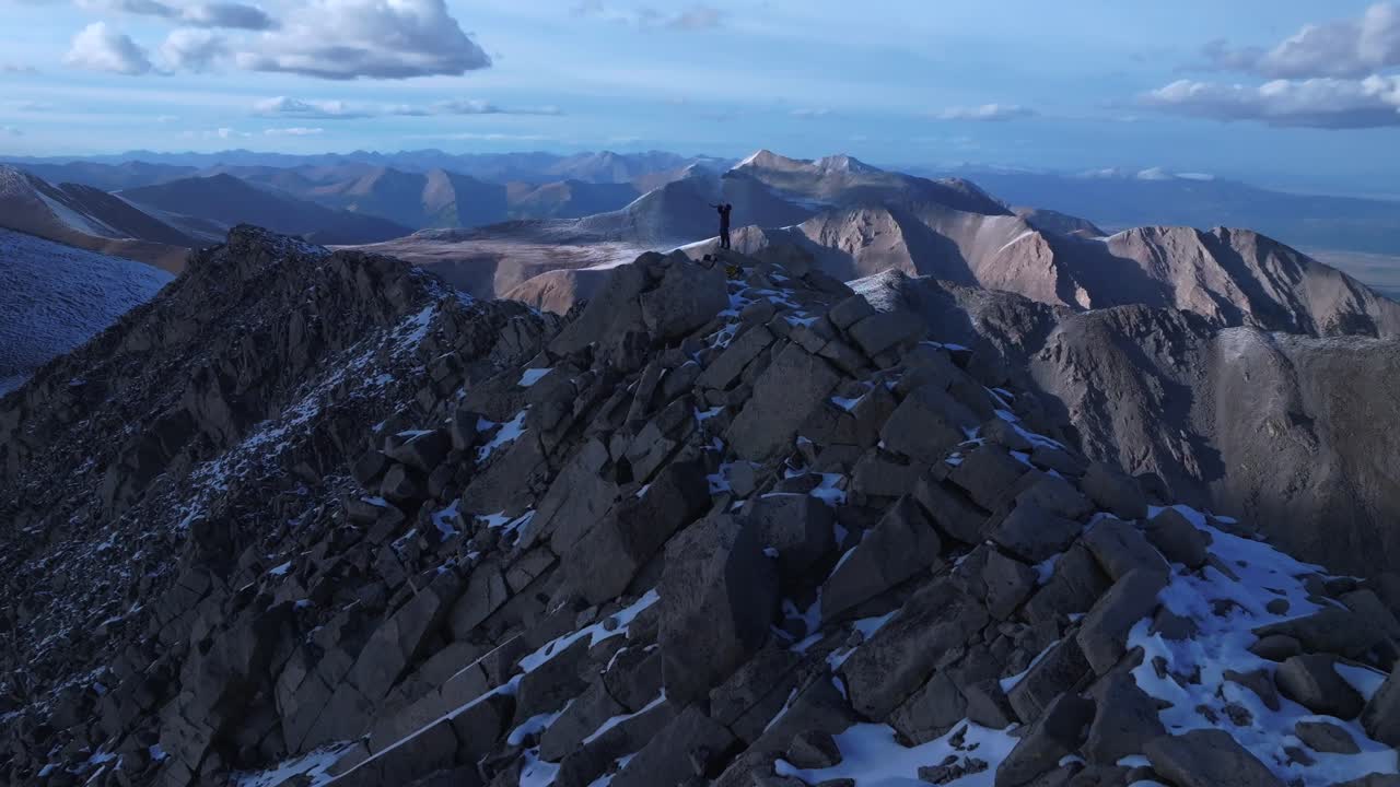 Top of Rocky Mountains summit Shofar ram horn music blown from hiker Jewish Christian tradition Walls of Jericho Mt Mount Shavano Elbert Huron Peak Central Colorado aerial drone sunset snow forward