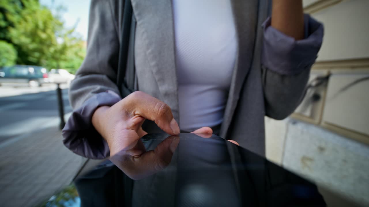 mujer usando tableta mientras bebe café en la calle