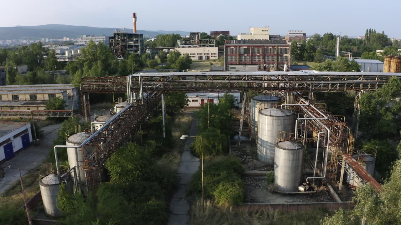 Aerial view of old pipeline and industrial chemical containers in abandoned factory area