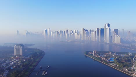 aerial view of fog over sharjah's lake, eye of emirates, sharjah skyline on a foggy morning, fog in gulf, united arab emirates, 4k footage