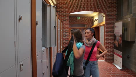 two students walking down hallway to locker