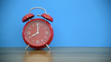 reloj despertador rojo en la mesa de madera