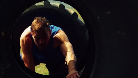 man crawling through the tires during obstacle course