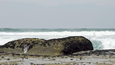 Slow-motion-shot-of-wave-crashing-onto-rock