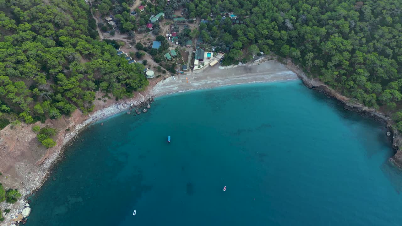 aerial view of a small beach village in the mountains surrounded by mediterranean sea - Kabak - Turkey