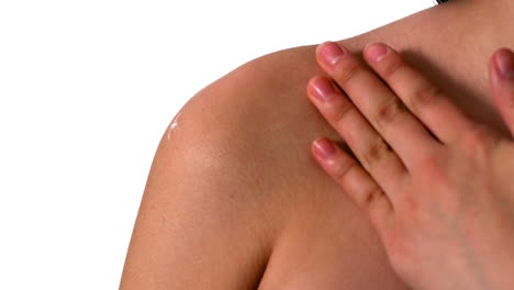 mujer frotando crema hidratante en su hombro
