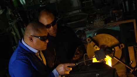 dos trabajadores masculinos que crean vidrio en una fábrica de vidrio 4k