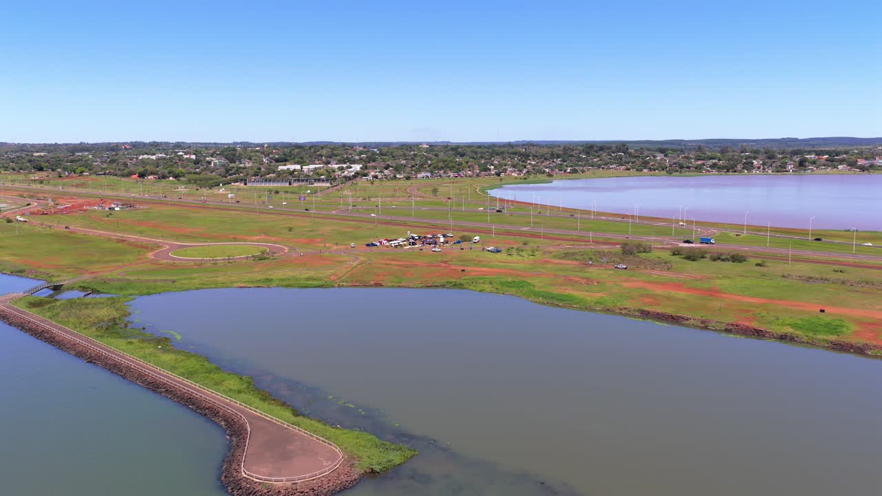 Drone clip frames southern access route to Posadas, surrounded by water, on a beautiful sunny day