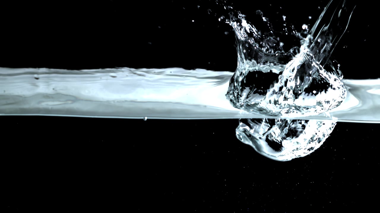 Acqua limpida che si versa e schizza con bolle su sfondo nero