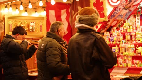 two people playing a game at a carnival booth