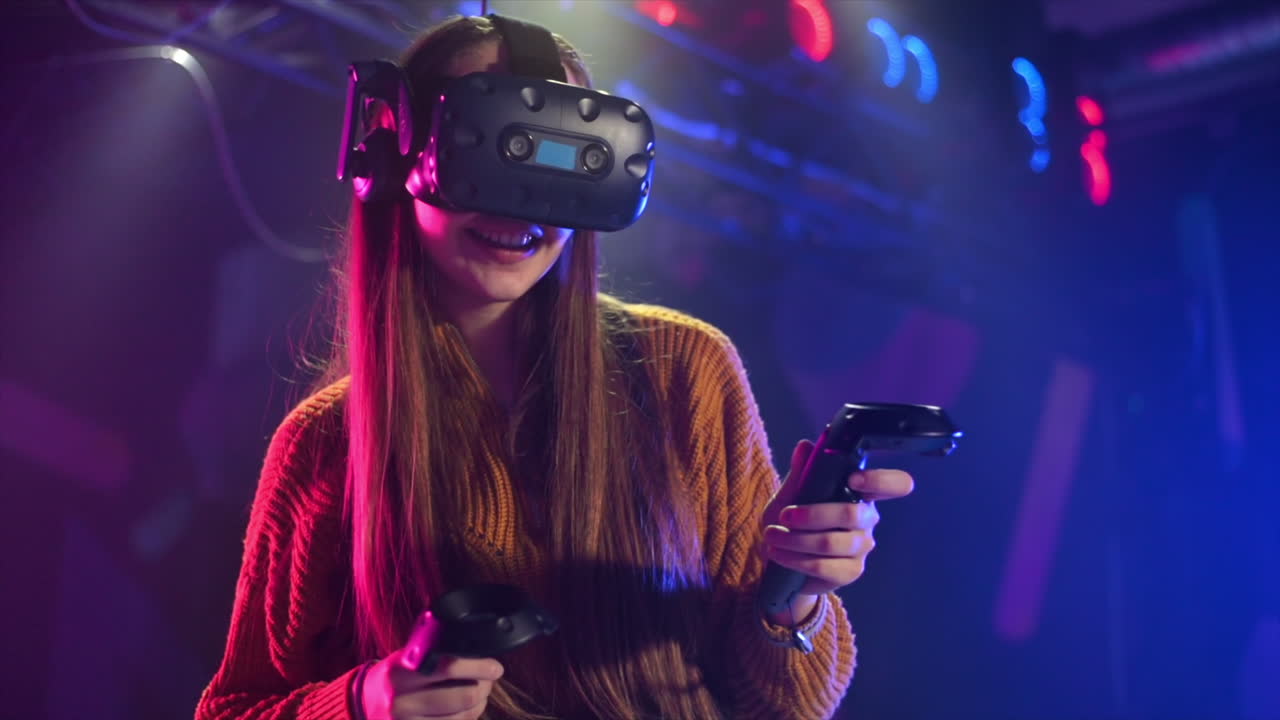 Una ragazza allegra e curiosa gioca su un tapis roulant VR con casco e controller. Rallentatore