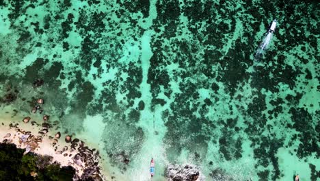 Aerial-Overhead-Flying-Over-Sunset-Beach-With-Turquoise-Waters-With-Coral