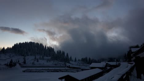 Ein-Mit-Winterschnee-Bedecktes-Bergdorf-Mit-Bewölktem-Himmel-Bei-Sonnenuntergang---Zeitraffer