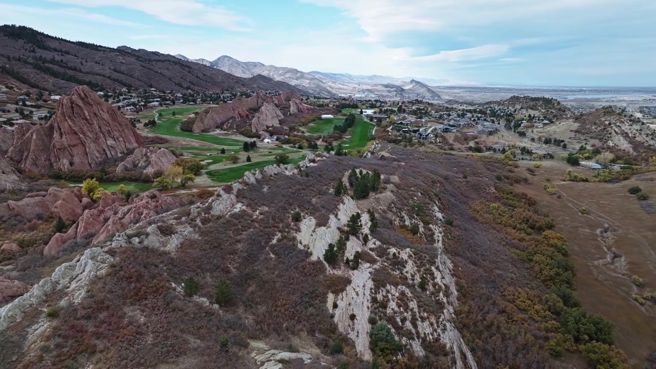 Keskin kayalık çıkıntılar ve tertemiz yeşil çim yolları ile Arrowhead golf sahasının dramatik havadan görünümü.