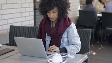 pretty girl with laptop in outside cafe