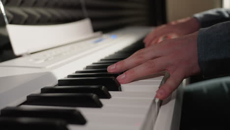 close-up shot of hands wearing a long sleeve shirt playing a white piano.focuses on the piano keys and fingers, capturing the detail and movement of the performance, with the background softly blurred