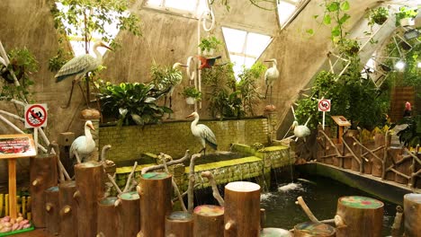 birds interacting near an indoor waterfall display