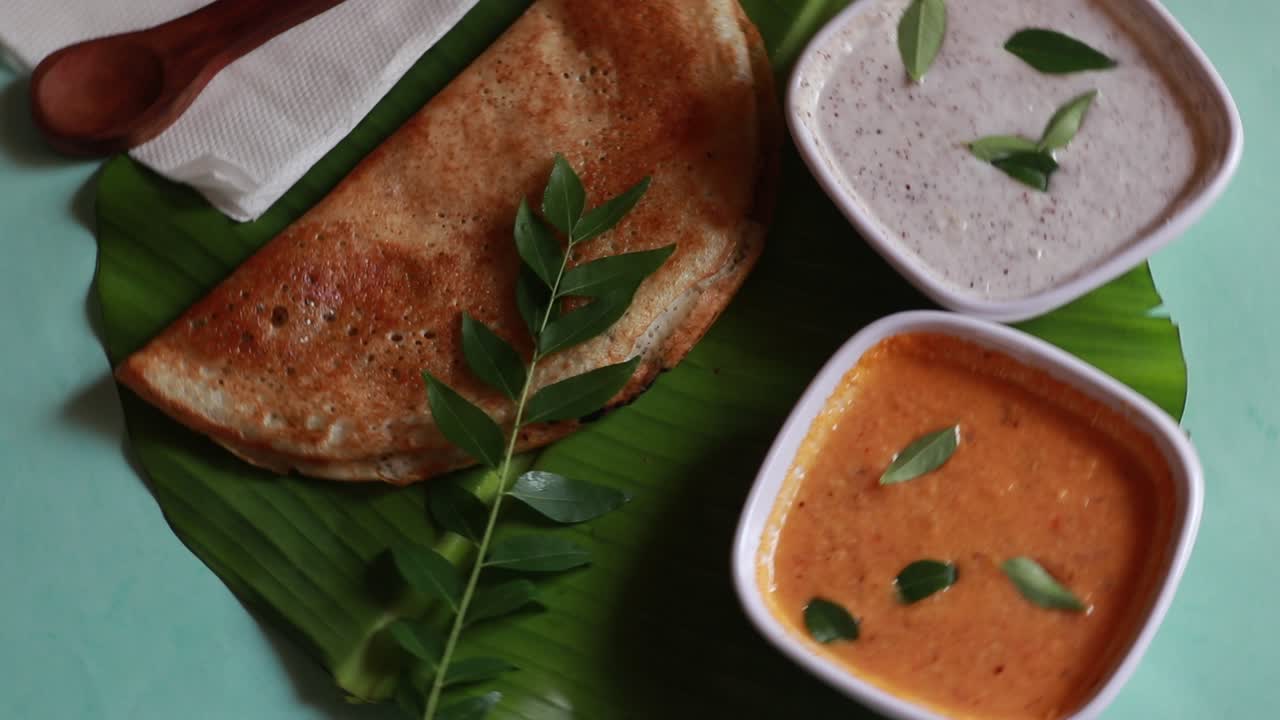 masala dosa giratoria, comida del sur de la india dosa, sambhar y chutney de coco sobre fondo verde