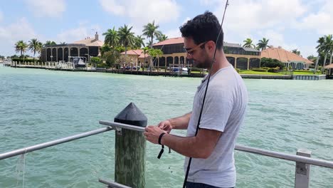 fisherman holds mangrove snapper in hand and unhooks small catch