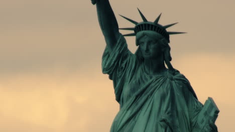 estatua de la libertad en primer plano con cielo naranja