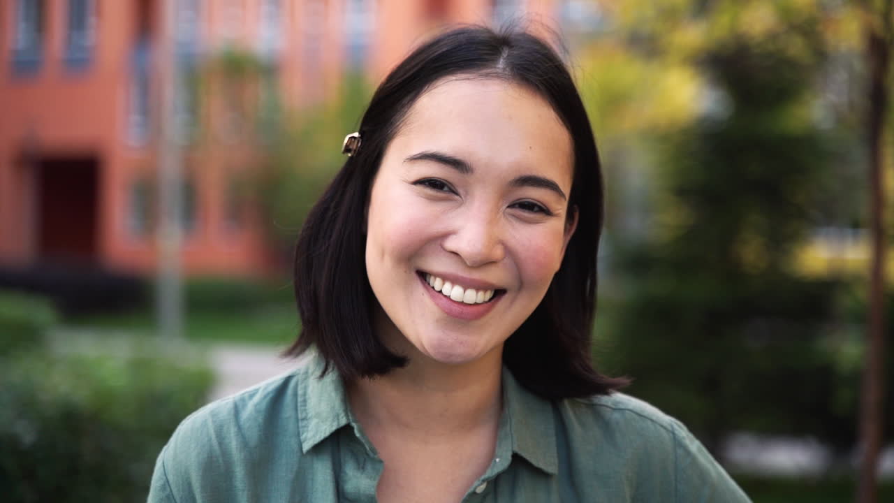 카메라를 보고 웃는 아름다운 일본 소녀의 야외 초상화 3