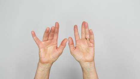 two hands are seen doing magic fingers with the fingers flickering energetically in front of a white background