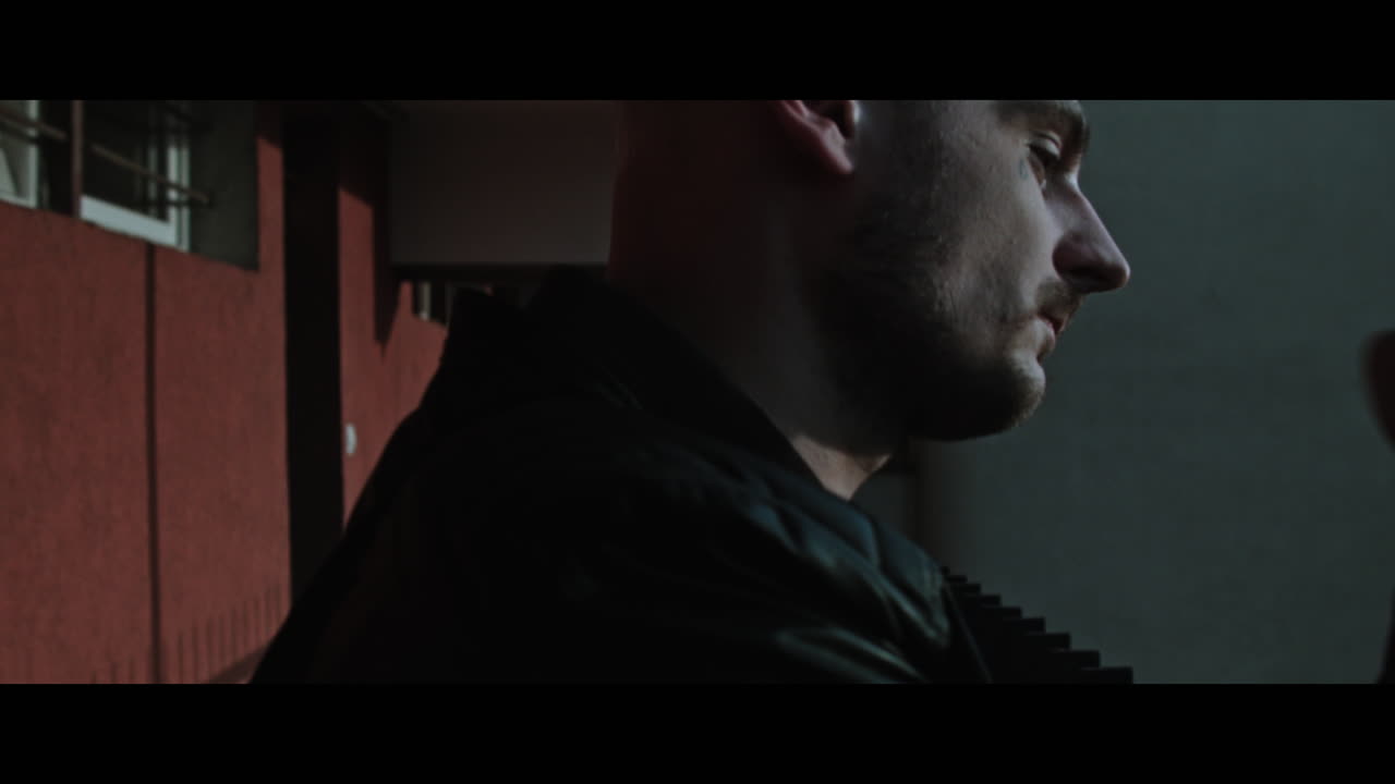 A bald gang member on guard