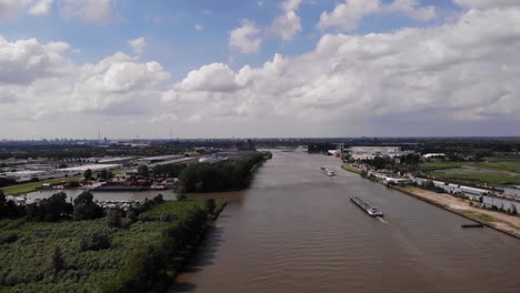 Barco-De-Alta-Vista-Aérea-Que-Viaja-A-Lo-Largo-Del-Río-Noord-En-Países-Bajos-Con-Puerto-Deportivo-A-La-Vista