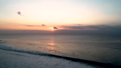 surfers at sunset: aerial view of a tropical beach