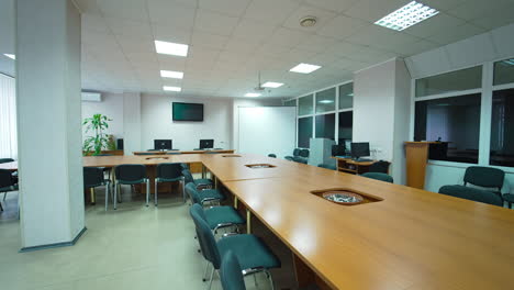 light spacious room for medical symposiums and meetings. conference room with long table and big whiteboard screen in the corner.