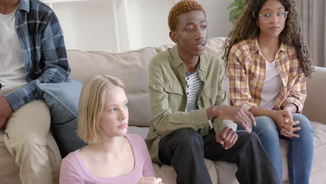 thoughtful diverse group of teenage friends at meeting talking at home, slow motion