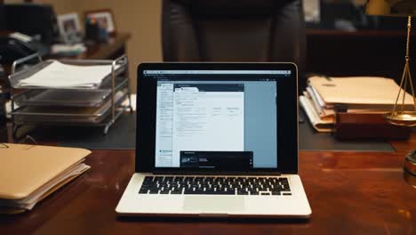 a professional workspace featuring a laptop displaying document work and organized office supplies in a corporate environment