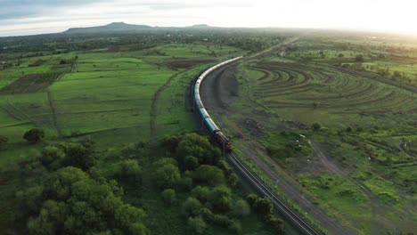 aerial view, passenger train moving through rural pune in india