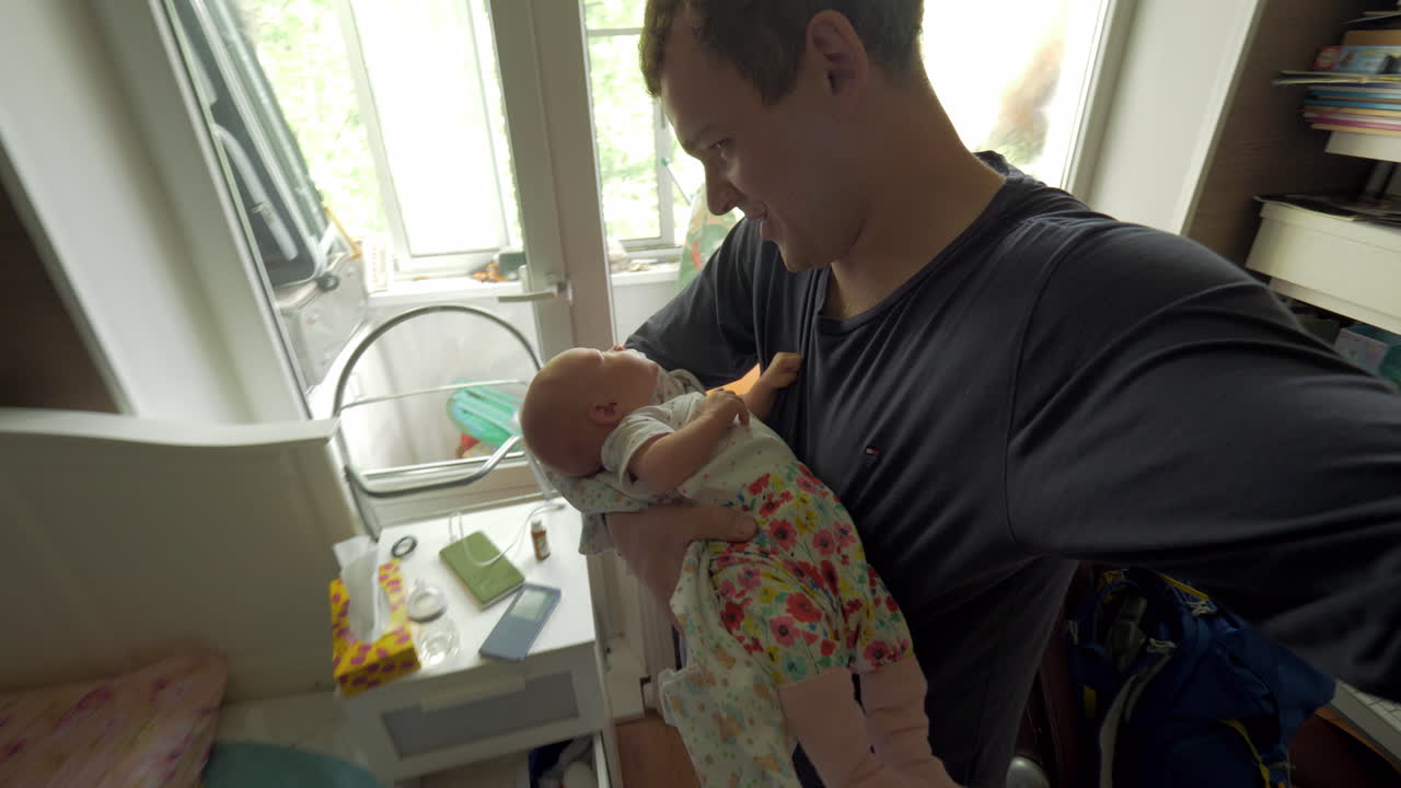 Dad lulling baby daughter at home